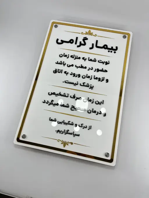 نمای کلی تابلو اطلاع‌رسانی مطب روی میز با چهار اسپیسر و قاب طلایی