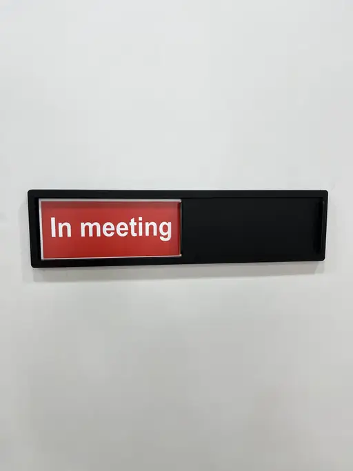 تابلو کشویی مشکی در حالت قرمز In meeting کنار در اتاق